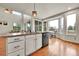 Kitchen island with granite countertops, a stainless steel dishwasher, hardwood floors, and view to Gathering room and eating area at 15767 E 109Th Ave, Commerce City, CO 80022
