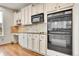 Kitchen featuring white cabinetry, granite countertops, stainless steel appliances, and hardwood floors at 15767 E 109Th Ave, Commerce City, CO 80022