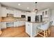 Spacious kitchen features white cabinets, granite countertops, stainless steel appliances, and hardwood floors at 15767 E 109Th Ave, Commerce City, CO 80022