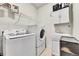 Laundry room with washer, dryer, sink, storage cabinets, and shelving at 15767 E 109Th Ave, Commerce City, CO 80022