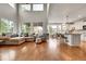 Open-concept living room features high ceilings, large windows, and adjoining kitchen at 15767 E 109Th Ave, Commerce City, CO 80022