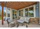 Comfortable outdoor seating under a pergola with stone accents and view to the home's interior at 15767 E 109Th Ave, Commerce City, CO 80022
