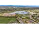 A birds eye view of a lake surrounded by trails and a neighborhood at 12432 Bellaire St, Thornton, CO 80241
