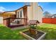 Expansive backyard showcasing a patio, a garden feature, and mature trees at 12432 Bellaire St, Thornton, CO 80241