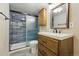 Modern bathroom featuring blue-tiled shower, wood vanity, and contemporary fixtures at 12432 Bellaire St, Thornton, CO 80241