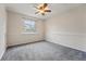 Bright bedroom with a ceiling fan, large window, neutral carpet, and chair rail at 12432 Bellaire St, Thornton, CO 80241
