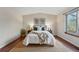 Serene bedroom featuring hardwood floors, a jute rug, and a comfortable bed with decorative pillows at 12432 Bellaire St, Thornton, CO 80241