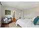 Spacious bedroom with wood-look floors, a comfortable bed, and ample natural light at 12432 Bellaire St, Thornton, CO 80241