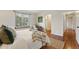 Bright bedroom showcasing a large window, wood-look floors, and cozy seating area at 12432 Bellaire St, Thornton, CO 80241