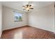 Bright bedroom with hardwood floors, a ceiling fan, and a large window offering neighborhood views at 12432 Bellaire St, Thornton, CO 80241