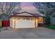 Home exterior with a two car garage, nice front yard and a covered porch at 12432 Bellaire St, Thornton, CO 80241