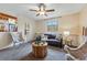 Cozy Gathering room with plush seating, modern ceiling fan, and an adjacent view to the kitchen at 12432 Bellaire St, Thornton, CO 80241