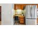 Kitchen nook with built-in desk and stainless steel refrigerator at 12432 Bellaire St, Thornton, CO 80241