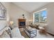 Bright living room featuring a brick fireplace, neutral colors, and large windows at 12432 Bellaire St, Thornton, CO 80241