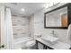Bright bathroom with a tub-shower combo, white tile, and a modern vanity at 1551 Larimer St # 1106, Denver, CO 80202