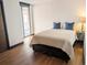 Well-lit bedroom with hardwood floors and balcony access, featuring natural light and views at 1551 Larimer St # 1106, Denver, CO 80202
