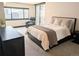 A bright bedroom featuring a king-sized bed, city views, and an inviting seating area at 1551 Larimer St # 1106, Denver, CO 80202