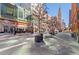 A charming street view with a Cheesecake Factory and sidewalks lined with trees and planters at 1551 Larimer St # 1106, Denver, CO 80202