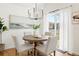 Dining area with a modern chandelier, round table, and sliding door to the backyard at 24784 E Arkansas Pl, Aurora, CO 80018