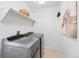Well-equipped laundry room with modern washer, dryer, and a charming decorative art piece at 24784 E Arkansas Pl, Aurora, CO 80018
