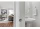 Stylish powder room with a pedestal sink and a glimpse into the cozy living room at 24784 E Arkansas Pl, Aurora, CO 80018