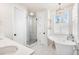 Bright bathroom featuring a glass-enclosed shower, standalone tub, and elegant chandelier at 2330 N Emerson St, Denver, CO 80205