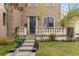 Attractive brick home with charming porch, blooming trees and lush green lawn at 2330 N Emerson St, Denver, CO 80205