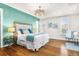 Spacious main bedroom featuring an accent wall, hardwood floors, a ceiling fan, and lots of natural light at 2330 N Emerson St, Denver, CO 80205