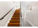 Staircase with wooden steps and dark metal railing leading upstairs at 2330 N Emerson St, Denver, CO 80205