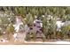 Aerial view of a brown home with solar panels, surrounded by mature pine trees and a long driveway at 838 Lakeshore Dr, Boulder, CO 80302