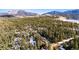 Lush wooded lot with scattered homes; scenic mountain view and frozen lake in background at 838 Lakeshore Dr, Boulder, CO 80302