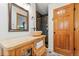 Bathroom featuring a log vanity with vessel sink and dark-tiled shower in this cozy cabin at 838 Lakeshore Dr, Boulder, CO 80302