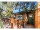 Charming home entrance featuring a wooden porch, green door and mature trees at 838 Lakeshore Dr, Boulder, CO 80302