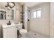 Sleek bathroom featuring a walk-in shower with white subway tiles, modern fixtures, and stylish black and white flooring at 5222 Xanadu St, Denver, CO 80239