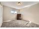 Neutral bedroom with a large window, a simple dresser, and plush carpeting, offering a comfortable space at 5222 Xanadu St, Denver, CO 80239