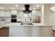 Modern kitchen features white cabinets, stainless steel appliances, and an island with cooktop at 7255 E Quincy Ave # 404, Denver, CO 80237