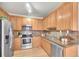 Well-lit kitchen features stainless steel appliances, granite counters, and wood cabinets at 10149 W 55Th Dr # 101, Arvada, CO 80002