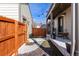 View of the backyard and porch area with string lights, wooden fence, and walkway at 12705 Ulster St, Thornton, CO 80602