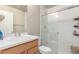 Bright bathroom showcasing a glass shower, single vanity with a white countertop and a small wooden storage bench at 12705 Ulster St, Thornton, CO 80602