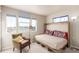 Neutral bedroom featuring an accent chair, a murphy bed, and many windows at 12705 Ulster St, Thornton, CO 80602