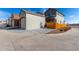 View of the garage, driveway, and the side yard with a wooden fence at 12705 Ulster St, Thornton, CO 80602