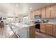 Bright kitchen features an island with seating, modern appliances, and natural wood cabinetry at 12705 Ulster St, Thornton, CO 80602