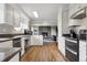 Open kitchen view with stainless steel appliances, white cabinets, breakfast bar, and stone fireplace in view at 8746 Sunridge Hollow Rd, Parker, CO 80134