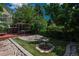 Well-manicured backyard features a stone feature, artificial turf and mature trees at 616 W 1St Ave, Denver, CO 80223