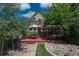 Lush backyard featuring a deck, pergola, and rock pathway surrounded by mature trees at 616 W 1St Ave, Denver, CO 80223