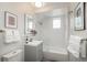 Bright bathroom with a vanity, mirror, and shower over the bath with glass screen and white subway tiles at 616 W 1St Ave, Denver, CO 80223