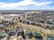 Scenic aerial view of home in a neighborhood with lake views and walking path, set against distant plains at 730 Pope Dr, Erie, CO 80516