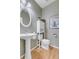 Cozy powder room with pedestal sink, white cabinetry, and charming decorative accents at 730 Pope Dr, Erie, CO 80516