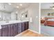 Bathroom with double sink vanity, light fixtures, mirror, and wood cabinets, offering ample counter and storage space at 730 Pope Dr, Erie, CO 80516