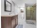 Cozy bathroom showcasing a vanity with a wood finish and a fully tiled shower with glass doors, plus a toilet at 730 Pope Dr, Erie, CO 80516